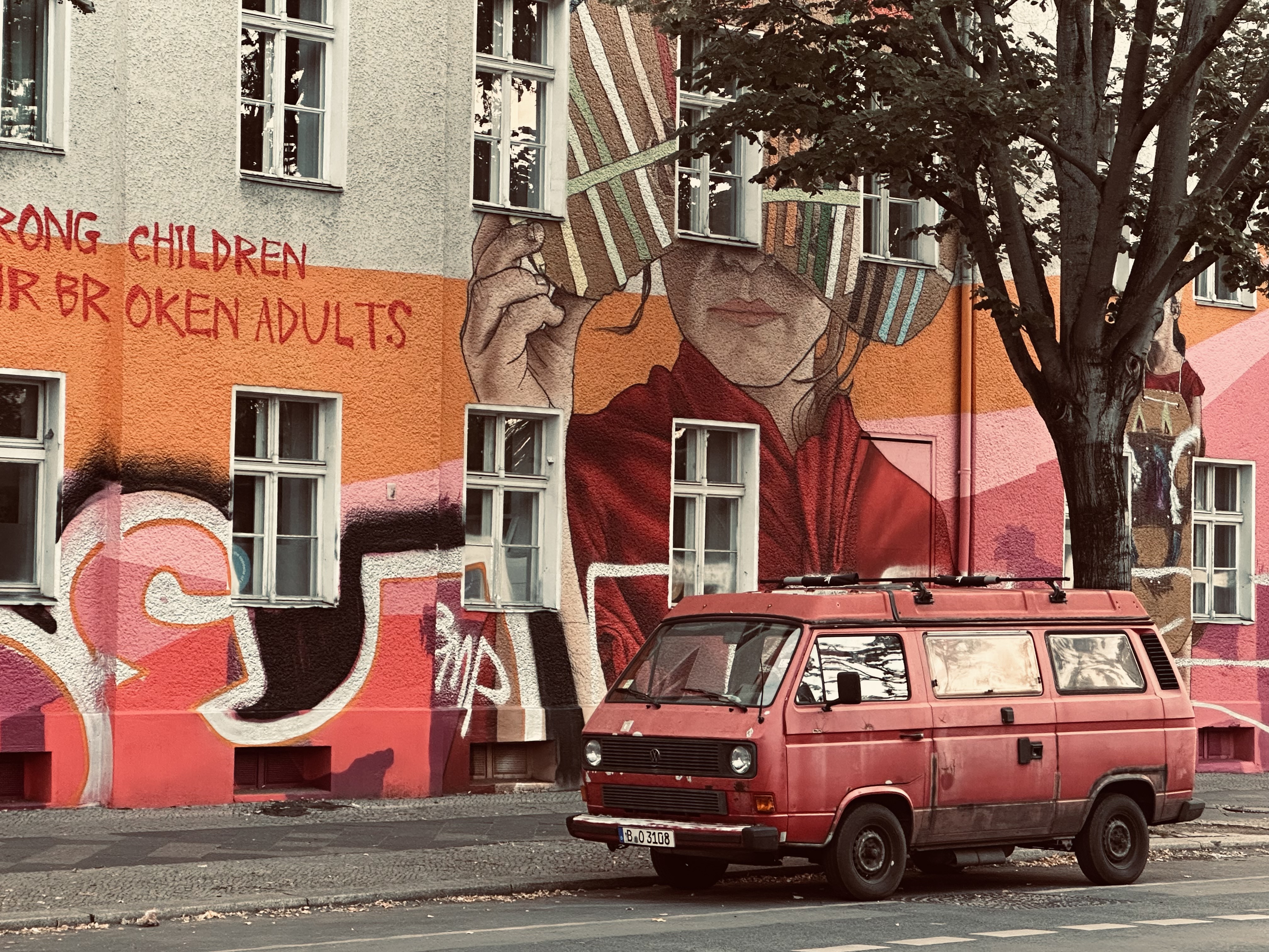 a red van in front of a grafitti painted wall