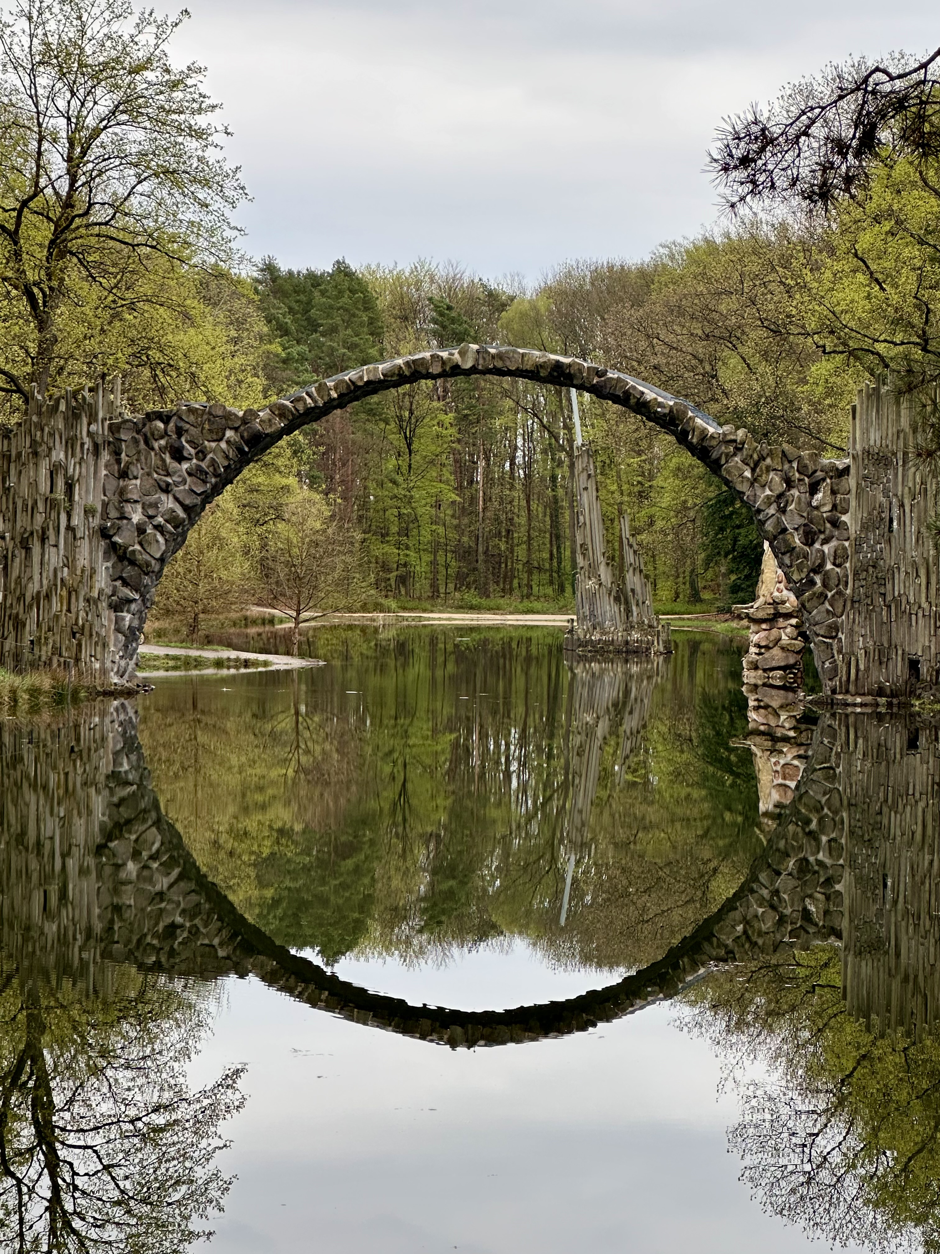 a picture of a bridge with its reflection in water making a circle
